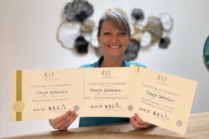 Tanja Derksen hält stolz ihre Zertifikate ihrer erfolgreich abgeschlossenen Weiterbildung.